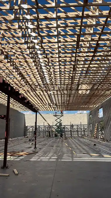 Steel columns and a wood truss ceiling framed over the open floor of a commercial building