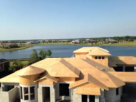 Aerial view of a fully decked hip roof on a lakefront custom home in Central Florida