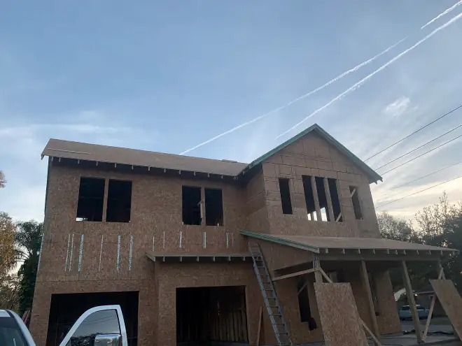 Two-story custom home framed and sheathed, cantilevered corner over the driveway