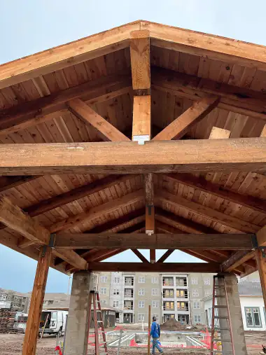 Underside of a finished heavy-timber cedar porch gable with exposed ridge and rafters