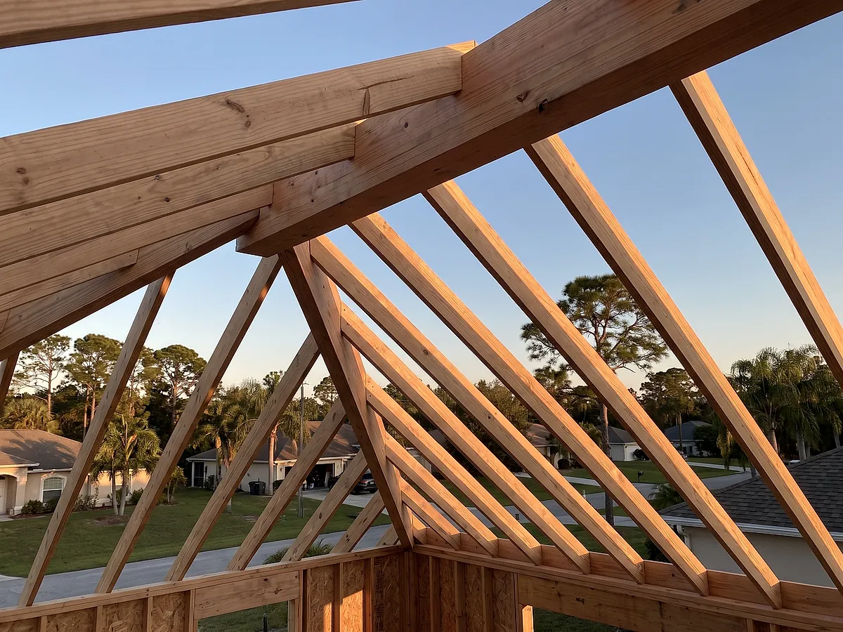 Newly framed custom home roof structure in warm afternoon light